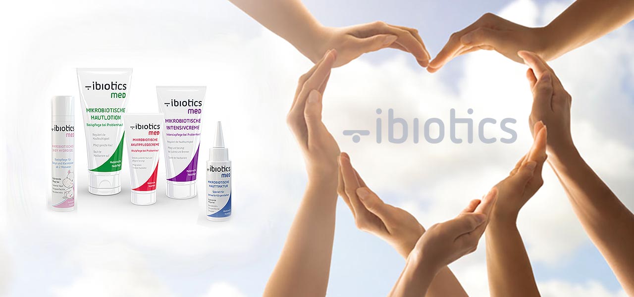 Manos formando un corazón en un fondo de nubes junto a tubos de crema.